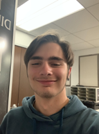 A selfie of Eric smiling in a hooded sweatshirt.