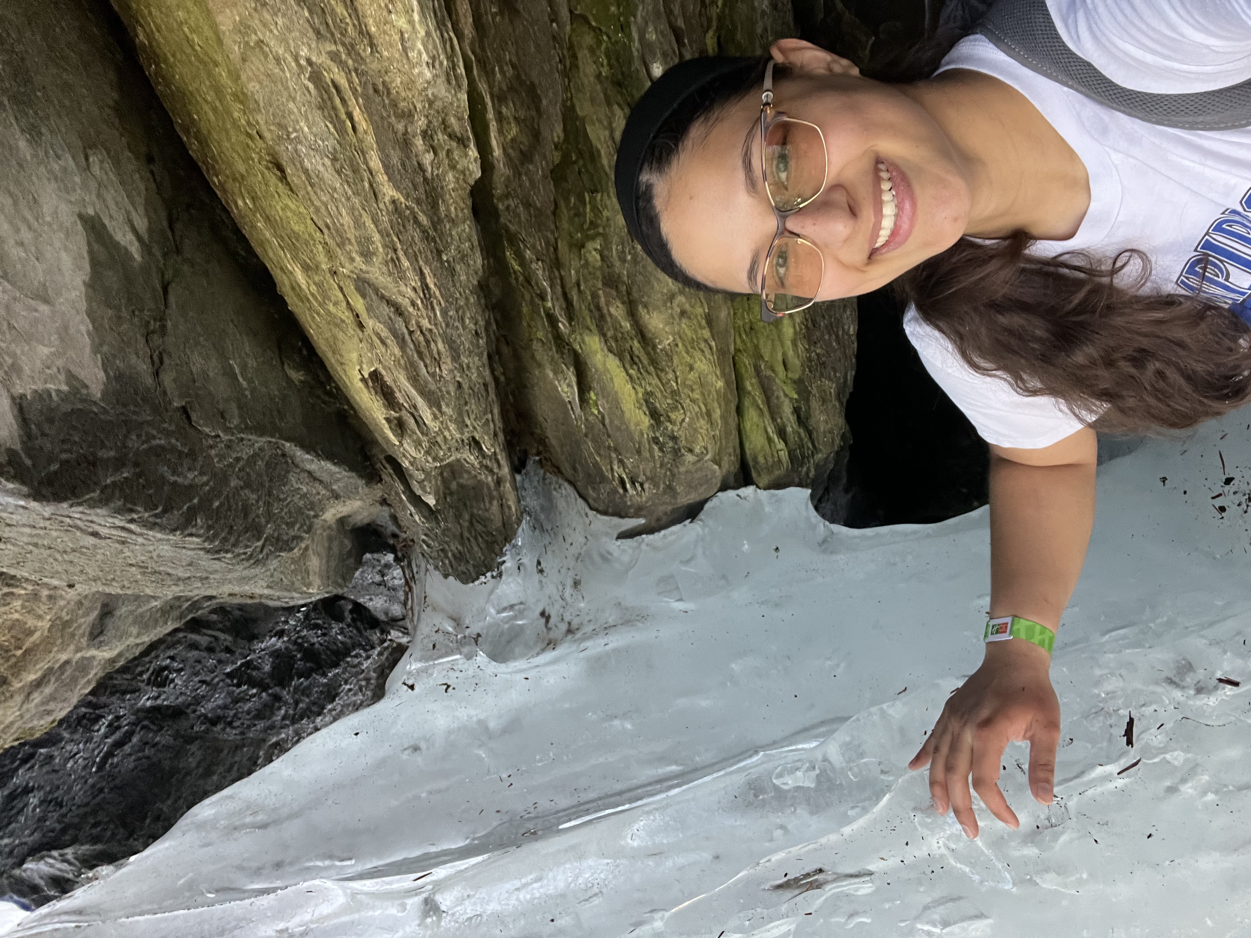 A photo of Kiani standing next to an ice formation. 