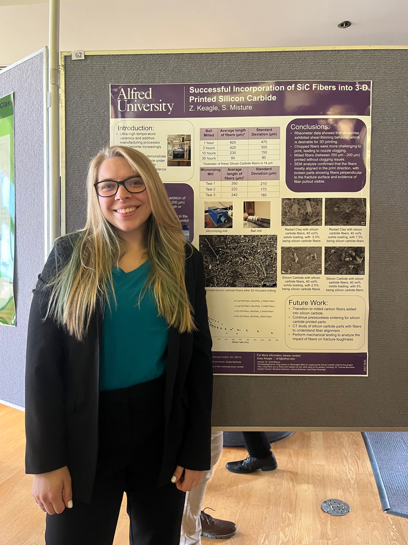 A photo of Zoey standing next to a poster presentation.